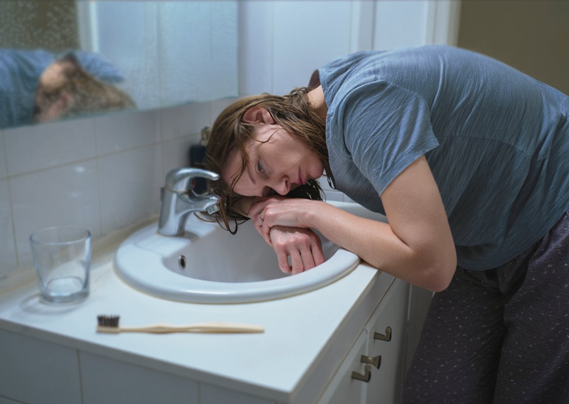 Женщина без сил облокотилась на раковину